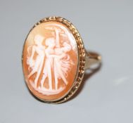 An early 20th century 9ct gold and 'Three Graces' carved oval cameo shell ring, size R, gross 3.5