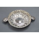An Edwardian repousse silver shallow bowl, with fluted lug handles, Wakely & Wheeler, London,