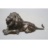 An early 20th century bronze model of a recumbent lion, length 23cm
