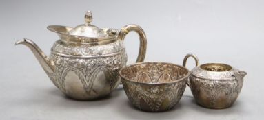 A late Victorian bachelor's embossed silver three piece tea set, Mappin & Webb, Sheffield, 1895,