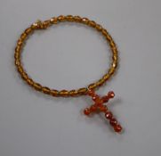 A gilt metal and facet cut amber set cross pendant, 6cm, on a similar amber necklace, gross weight