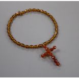 A gilt metal and facet cut amber set cross pendant, 6cm, on a similar amber necklace, gross weight