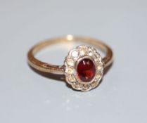 A 1970's 9ct gold, garnet and white sapphire? set oval cluster ring, size L, gross 1.6 grams.