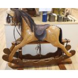 An Ian Armstrong carved rocking horse with brown leather tack
