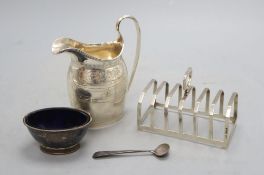 An Edwardian silver milk jug, 13.3cm, a silver toast rack, silver salt and silver condiment spoon,