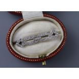 A 1920's white metal and diamond set openwork brooch, 31mm, gross 2.8 grams, with a Tessier box.