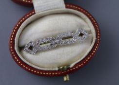 A 1920's white metal and diamond set openwork brooch, 31mm, gross 2.8 grams, with a Tessier box.