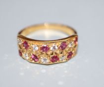 A modern 18ct, eight stone ruby and eight stone diamond set half hoop dress ring, size L/M, gross