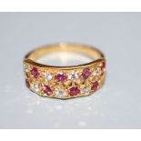 A modern 18ct, eight stone ruby and eight stone diamond set half hoop dress ring, size L/M, gross