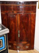 A George III mahogany bowfront hanging corner cabinet, W.86cm, D.48cm, H.126cm