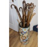 A group of assorted walking canes, some silver mounted, in a ceramic stand