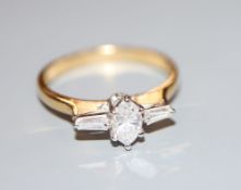A modern 18ct gold, marquise and trapeze cut diamond set three stone dress ring, size Q, gross 3.1