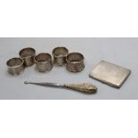 Five assorted silver napkin rings including a pair, a silver cigarette case and button hook, 7oz.