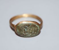 An antique gilt metal and oval bronze plaque set ring, size P.CONDITION: Visible verdigris to top of