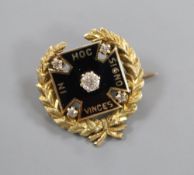 An early 20th century yellow metal, black enamel and diamond set brooch, inscribed in latin 'In this