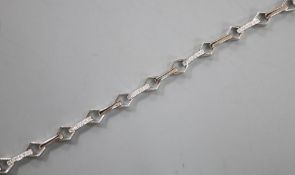 A modern 18k and diamond chip set baton and diamond shaped link line bracelet, 17.5cm, gross 9.5