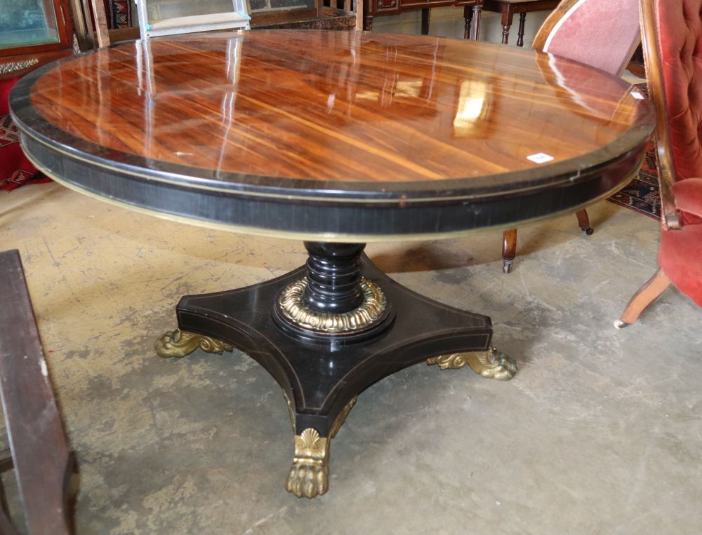 A George IV rosewood and ebony gilt metal mounted circular breakfast table, on cast lion paws