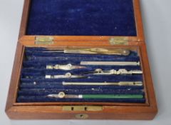 A mahogany box containing drawing instruments and a modern coaster