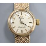 A 9ct gold lady's Omega gold manual wind wristwatch on 9ct gold bracelet, overall length 17.8cm,