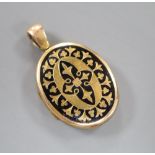 A Victorian engraved yellow metal and black enamel oval mourning locket, 3cm, gross 9.9 grams.