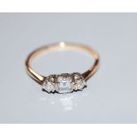 A yellow metal and three stone diamond ring, with central rectangular stone, size M, gross 1.6