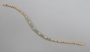 A modern 375 yellow metal, emerald and diamond chip set line bracelet, 18.2cm, gross 7.5 grams.