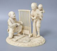 A Meiji ivory okimono of a lady carrying a child and man beside a weaving loom, height 12cm