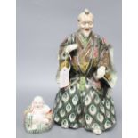 A Japanese ceramic model of a Samurai and a Chinese enamelled ceramic figure of a Buddha, tallest