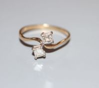 A 9ct gold and two stone square cut diamond set crossover ring, size O, gross 1.5 grams.CONDITION: