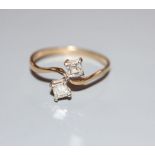 A 9ct gold and two stone square cut diamond set crossover ring, size O, gross 1.5 grams.CONDITION: