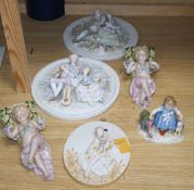 A group of Continental porcelain wall plaques and pockets and a figure group