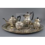 An early-mid 20th century Indian five piece white metal tea service with tea tray, all pieces