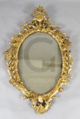 A George III carved giltwood wall mirror, with flowers in a ewer crest and ho-ho birds to each