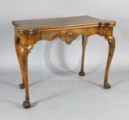 A George I walnut gaming table, with eared serpentine rectangular top, scallop shell carved