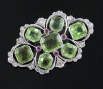 A mid 20th century pierced white gold, peridot, ruby and diamond set shaped oval brooch, set with