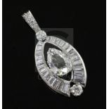 A platinum or white gold, pear, baguette and round cut diamond set elliptical shaped pendant, the