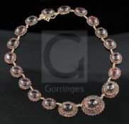 A late Victorian gold, cabochon and shaped cut garnet graduated oval link necklace, with safety