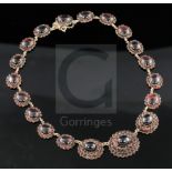 A late Victorian gold, cabochon and shaped cut garnet graduated oval link necklace, with safety