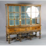 A 1930's Queen Anne revival walnut display cabinet, with two barred glazed doors flanking a