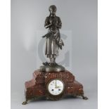 A 19th century French bronze and rouge marble mantel clock, surmounted with a bronze figure by