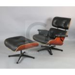 A Charles Eames cherrywood and black leather lounge chair with matching stool, made by Vitra,