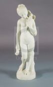 Bouzadou. A carved white marble figure of a nude girl feeding a sheath of corn to a bird
