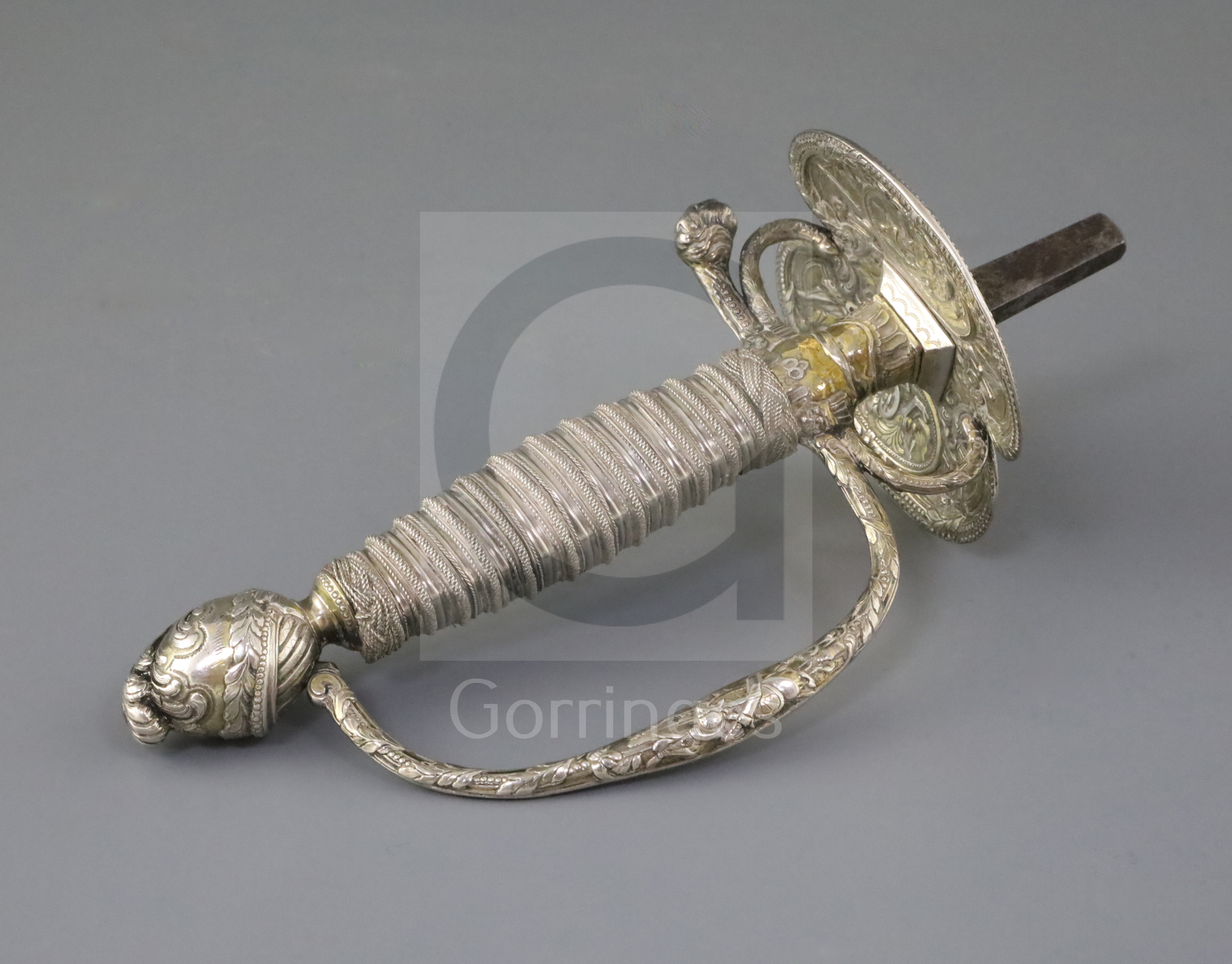 A 19th century Continental silver gilt sword hilt, decorated with military trophies, a helm and