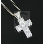 A modern 18ct white gold and six stone Princess cut diamond set cross pendant by Theo Fennell, on an