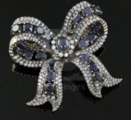 A 20th century gold, sapphire and diamond encrusted ribbon bow clip brooch, set with cabochon and