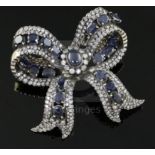 A 20th century gold, sapphire and diamond encrusted ribbon bow clip brooch, set with cabochon and