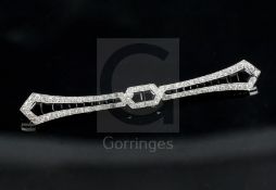 A 1930's/1940's French platinum, graduated diamond and black onyx bar brooch, probably by Boucheron,