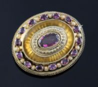 A Victorian gold (tests as 15ct) and garnet set oval pendant brooch, set with fifteen oval cut