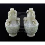 A pair of Chinese carved jade vases and covers, with ring handles and decorated with foliate motifs,