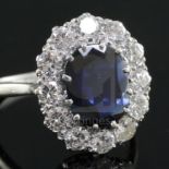 A modern white gold?, sapphire and diamond set oval cluster ring, the oval cut sapphire weighing
